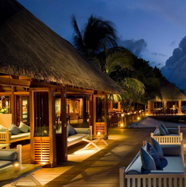 Cozy outdoor lounge area with warm lighting at dusk.