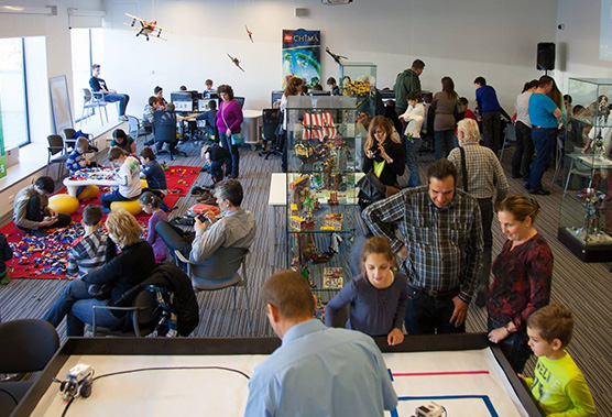 Busy community center with people engaged in various activities and conversations.